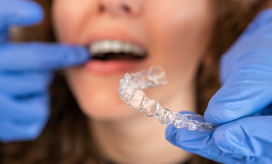 Does invisalign Hurt? A doctor putting on invisalign in patients mouth.