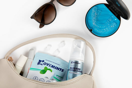 Movemints Aligner Mints, Whitening Foam, lip gloss and perfume coming out of a woman's purse, along with sunglasses and a pair of aligners in an open case
