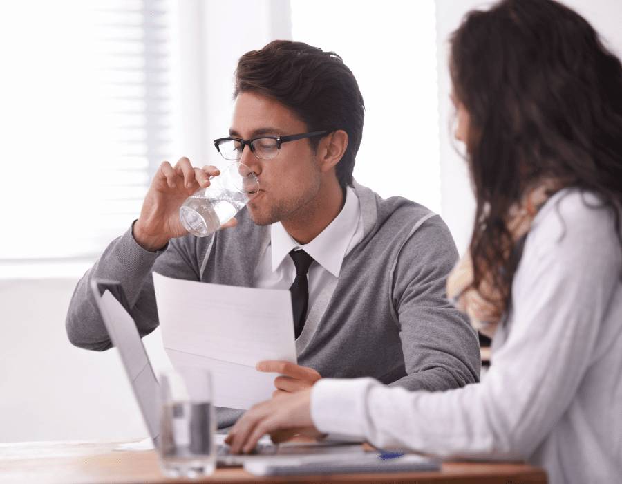 man drinking water at job interview