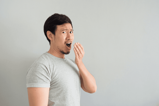 man looking at camera checking breath